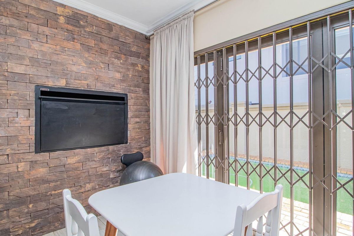 Living area featuring a textured stone feature wall with a built-in fireplace and sliding glass doors leading to the outdoor space.