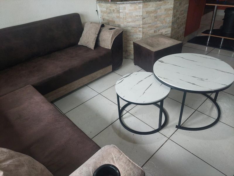 A living area featuring ceramic floor tiles and a stone-clad feature wall, providing a neutral base for interior design.