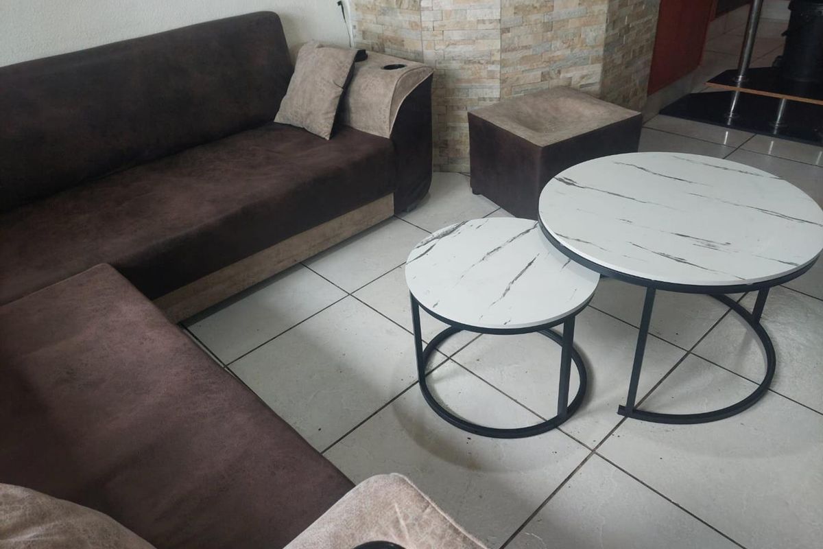 A living area featuring ceramic floor tiles and a stone-clad feature wall, providing a neutral base for interior design.