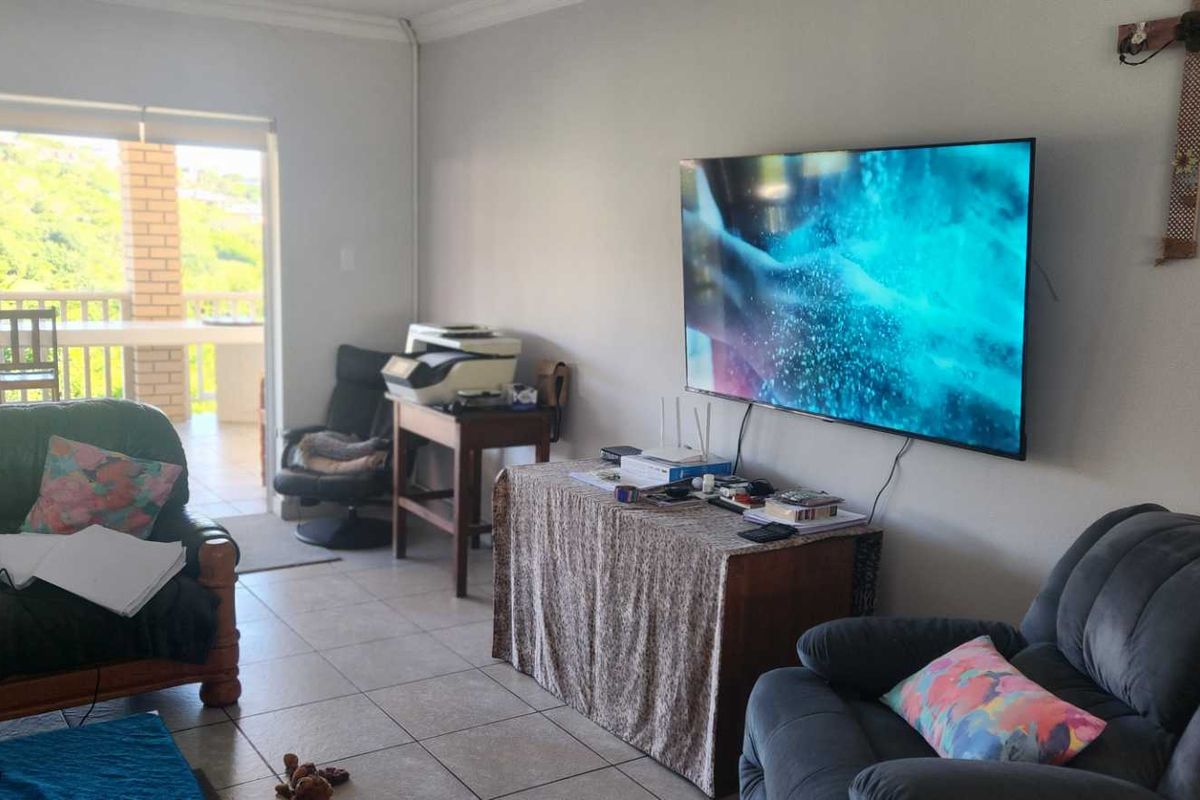 Living room featuring tiled flooring and large sliding glass doors providing access to an outdoor patio area.