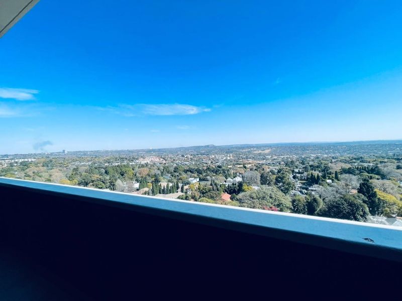 Elevated panoramic view of the surrounding suburban landscape and horizon, captured from an apartment balcony.