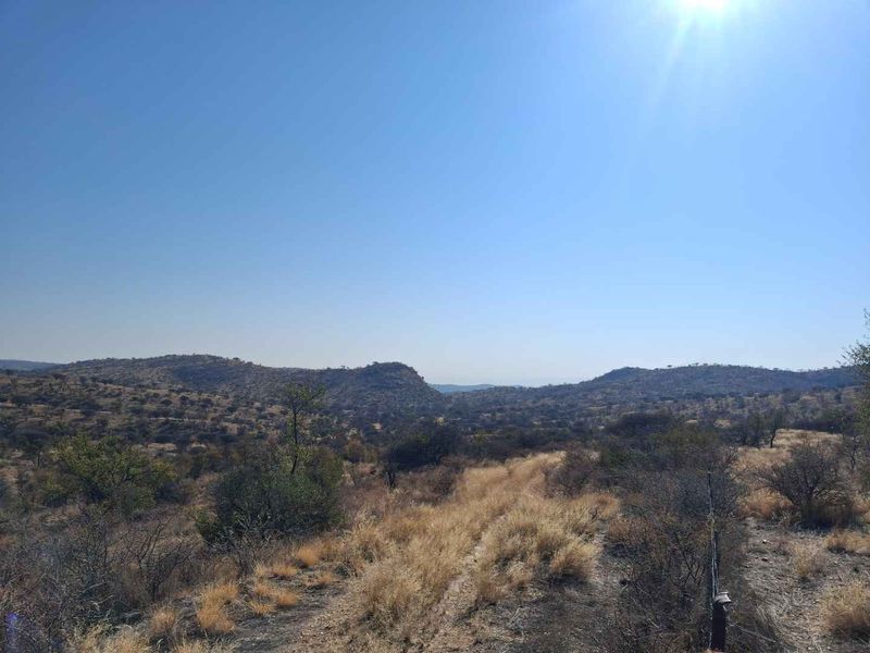 A scenic landscape view of the surrounding hills and natural vegetation on the small holding property.