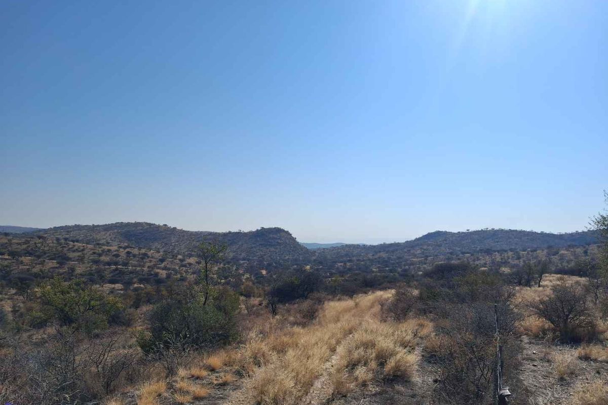 A scenic landscape view of the surrounding hills and natural vegetation on the small holding property.