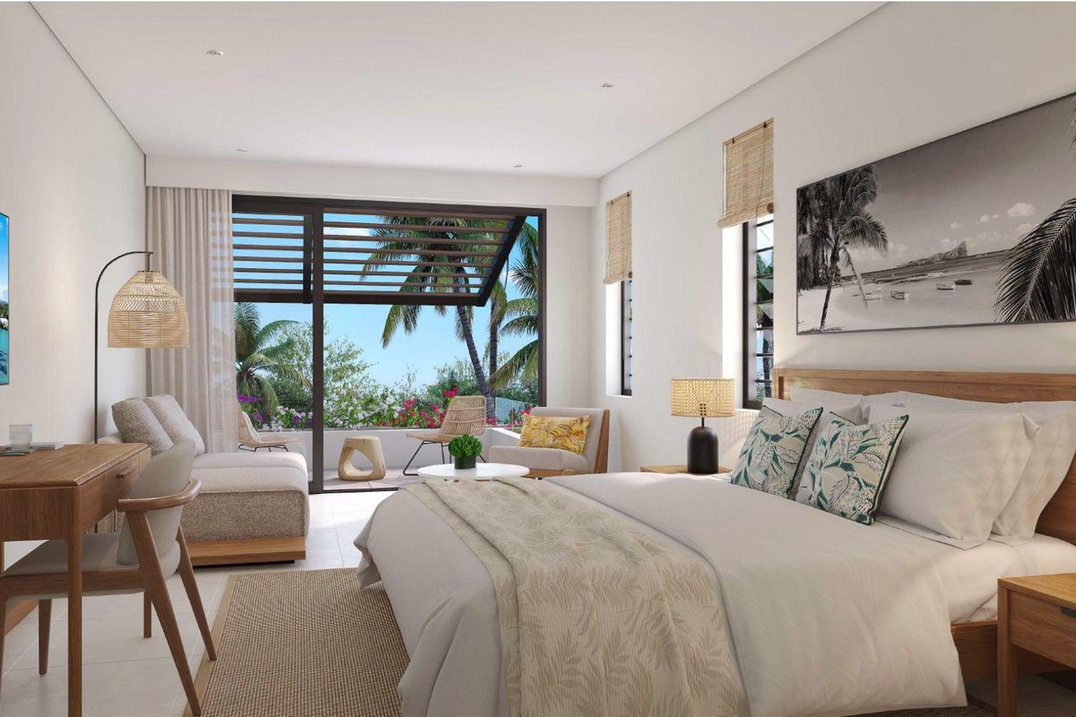 A bright, modern bedroom featuring large sliding glass doors that open onto a private balcony with tropical views.
