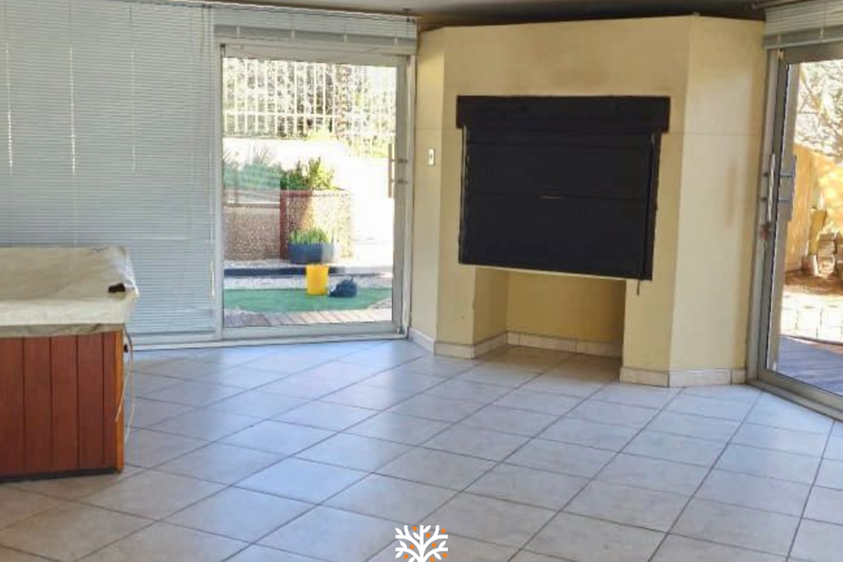 Spacious living area featuring a built-in fireplace, tiled flooring, and large sliding glass doors providing direct access to the outdoor patio area.
