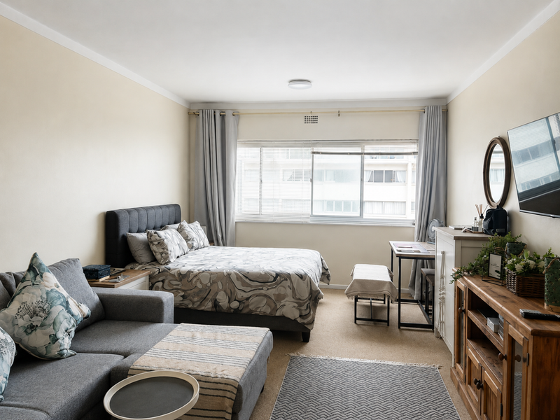 A well-maintained bedroom featuring neutral walls, carpeted flooring, and a large sliding window that allows for natural light.