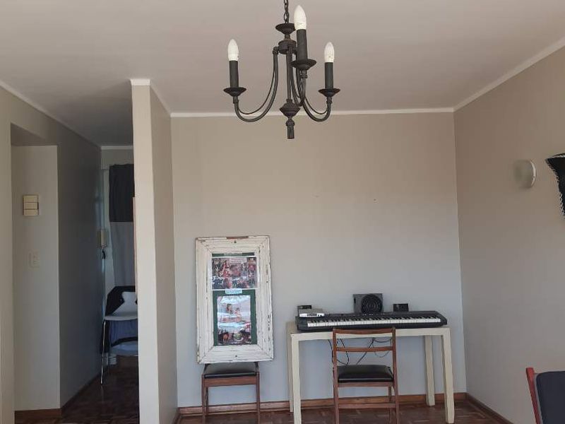 A living area featuring classic parquet flooring and a central chandelier, providing a neutral foundation for interior design updates.
