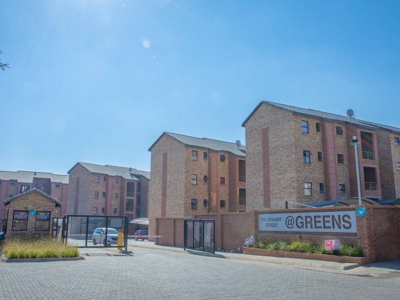 Front view of the apartment complex entrance featuring face brick buildings, a secure gated access point, and a paved driveway.