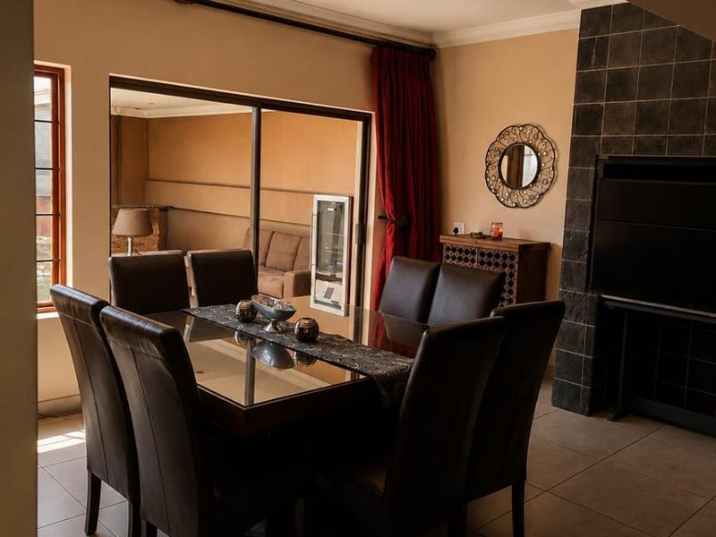 A dining area featuring tiled flooring, a built-in fireplace with dark tiling, and a sliding glass door providing access to an outdoor space.
