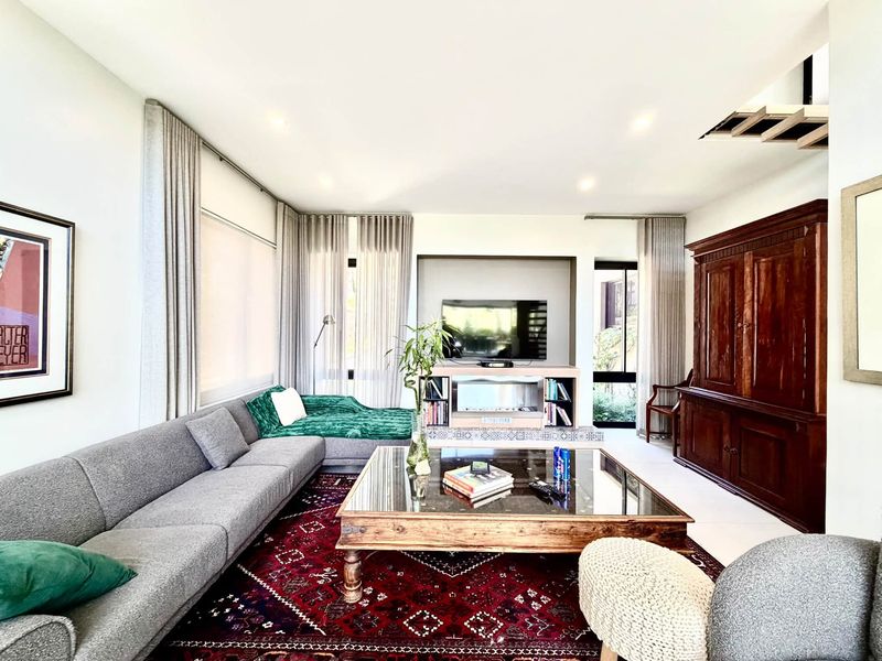 Spacious living room featuring a built-in media console with a fireplace, recessed lighting, and large windows with integrated curtain tracks.