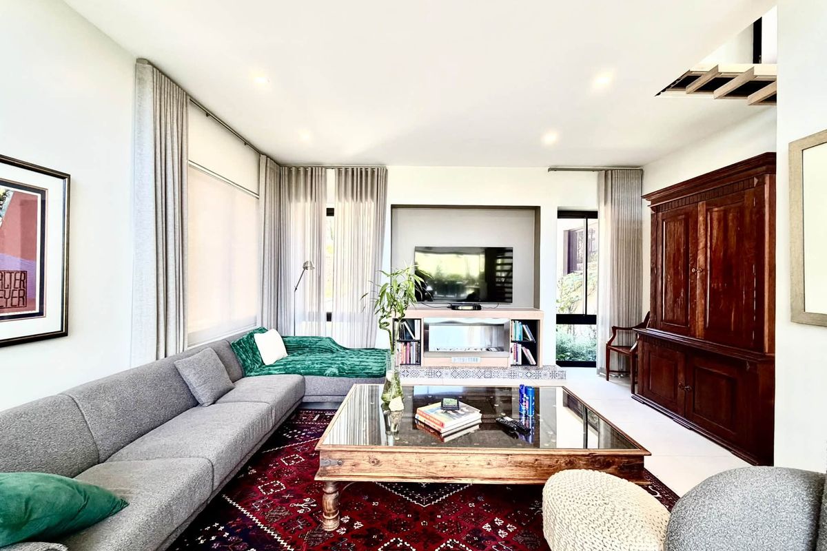 Spacious living room featuring a built-in media console with a fireplace, recessed lighting, and large windows with integrated curtain tracks.