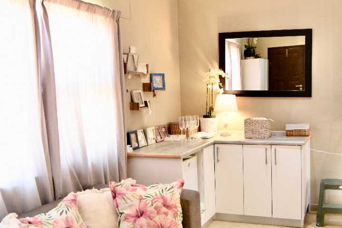 A living area featuring built-in cabinetry with a countertop, recessed lighting, and cove cornicing, showing signs of wall moisture damage.