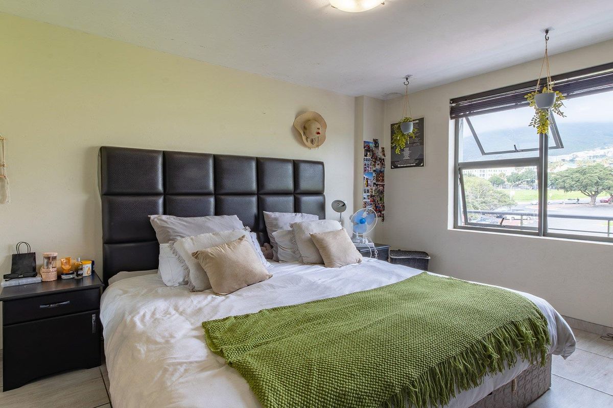 A bedroom featuring tiled flooring and an awning window with natural light, providing a functional space for rest.