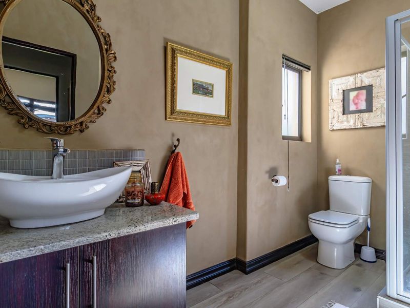 A well-maintained bathroom featuring a modern vessel sink on a granite vanity, a separate shower enclosure, and neutral wall finishes.