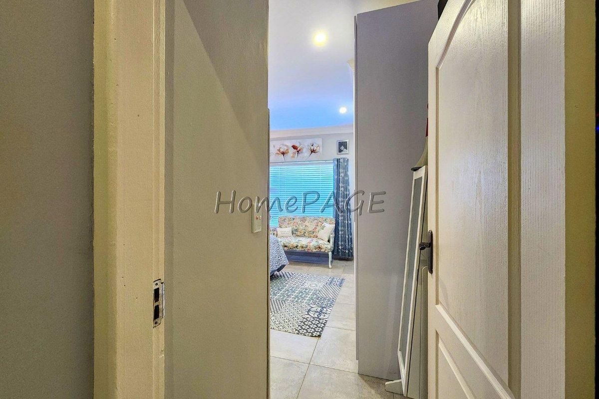 A view through an open doorway into a bedroom featuring tiled flooring and recessed ceiling lighting.
