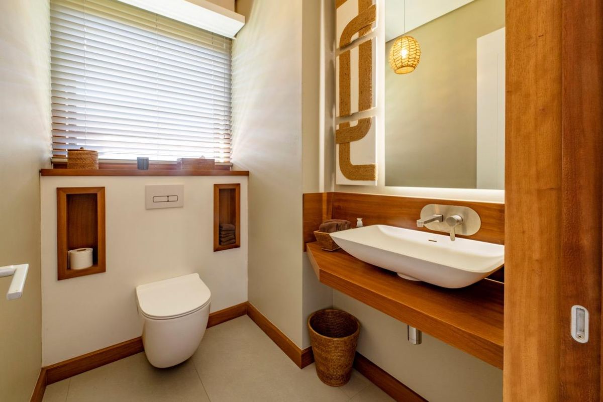 Modern guest bathroom featuring a wall-mounted toilet, floating timber vanity with a vessel sink, and integrated wall niches.