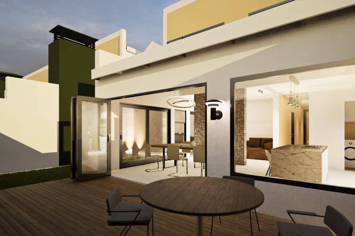 A modern townhouse exterior featuring a wooden deck patio with large glass sliding doors opening into an open-plan living and kitchen area.
