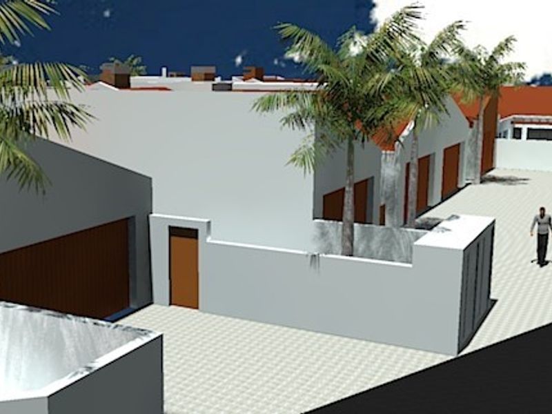 A 3D architectural rendering showing the front exterior of a townhouse complex with garage access and a paved driveway.