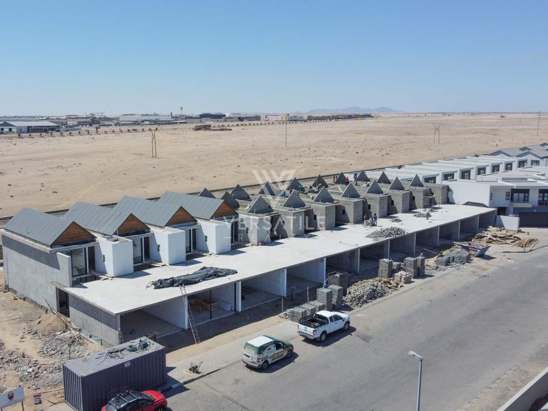 Aerial view of a townhouse development currently under construction, showing multiple units in various stages of completion.