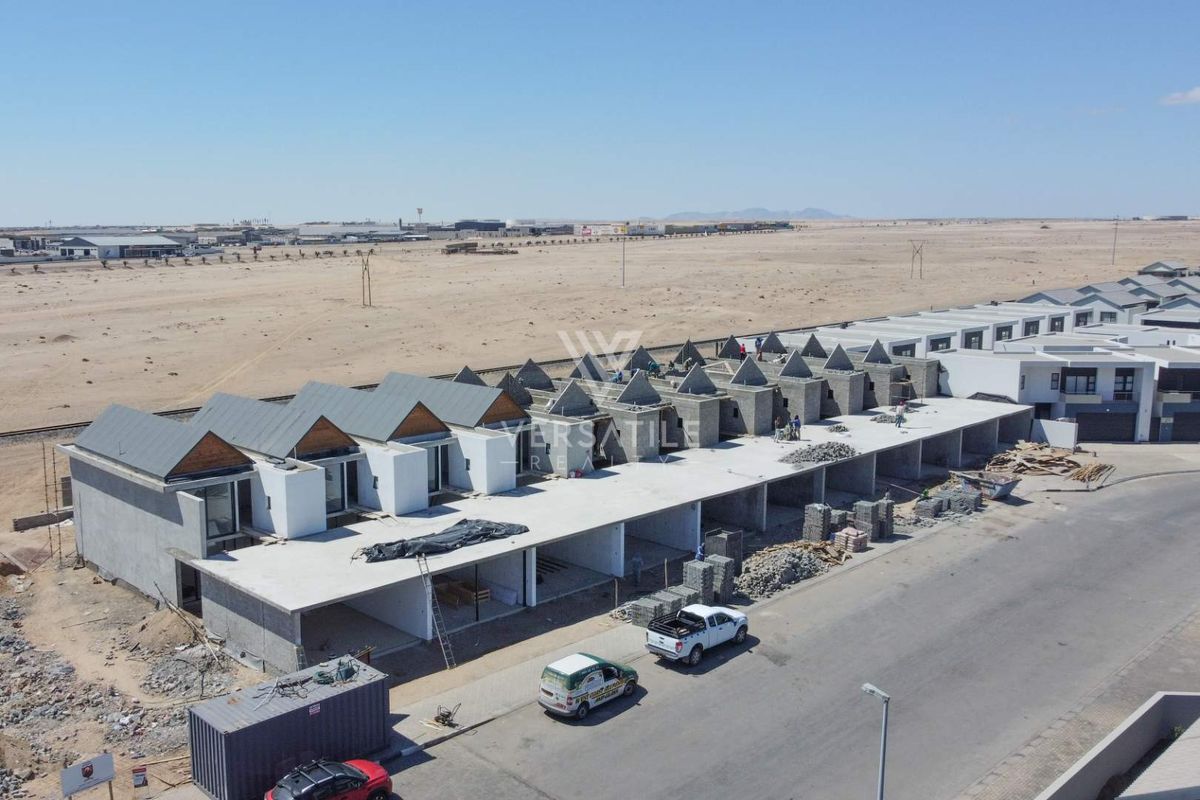 Aerial view of a townhouse development currently under construction, showing multiple units in various stages of completion.