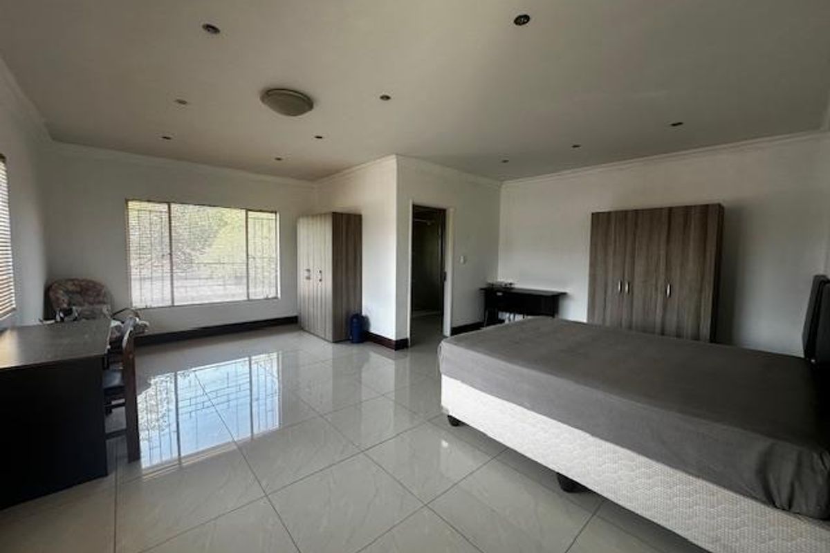 Spacious bedroom featuring large format floor tiles, recessed ceiling lighting, and built-in cabinetry.
