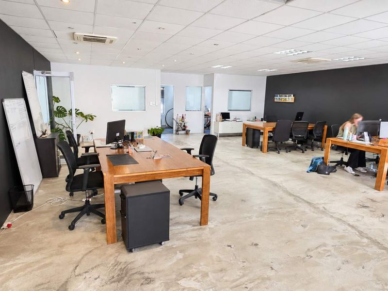 Open-plan office space featuring a suspended ceiling, recessed lighting, ducted air conditioning, and polished concrete flooring.