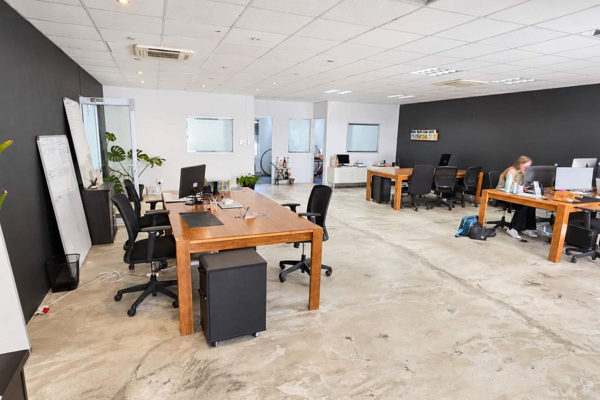Open-plan office space featuring a suspended ceiling, recessed lighting, ducted air conditioning, and polished concrete flooring.