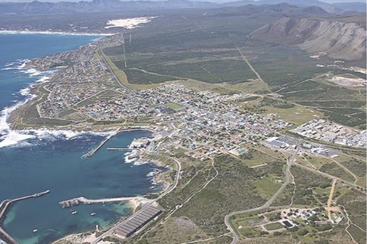 An aerial view of the coastal town, showcasing the harbour, surrounding landscape, and local road infrastructure.