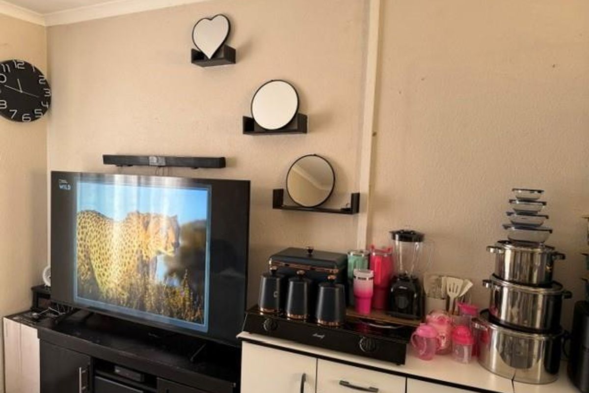 A living area featuring a wall-mounted television and built-in cabinetry providing storage and surface space.