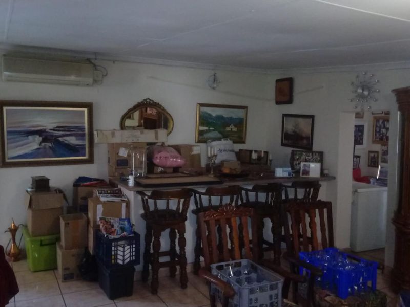 A living area featuring a built-in breakfast bar, tiled flooring, and a wall-mounted split-system air conditioning unit.