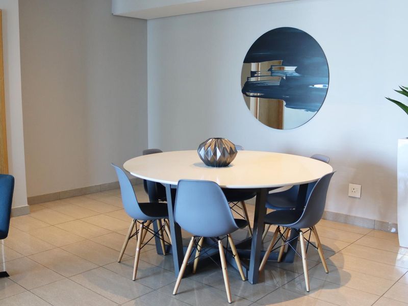 A well-maintained dining area featuring neutral tiled flooring and clean wall finishes, providing a bright and functional space for meals.