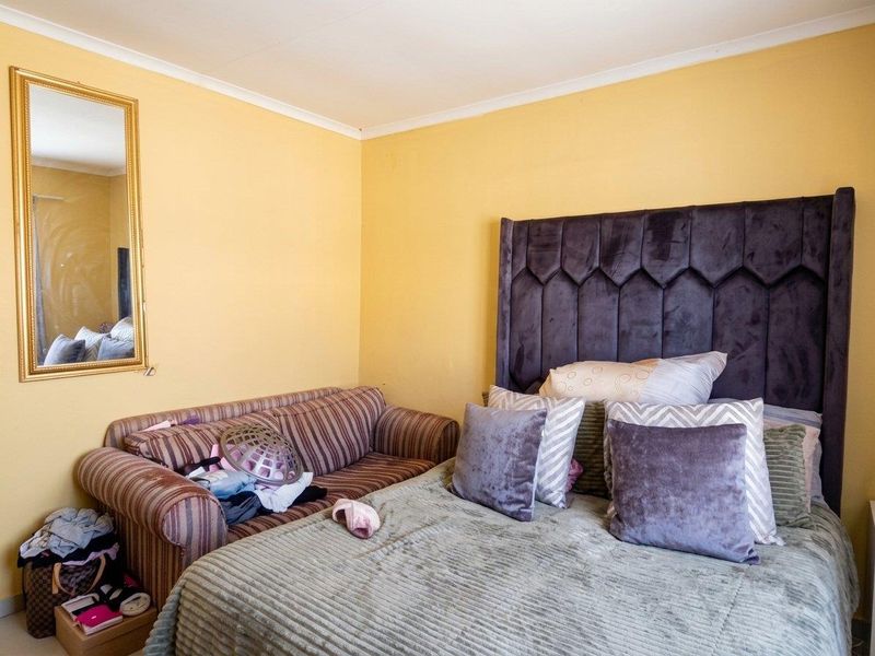 A bedroom featuring yellow painted walls and coving, providing a functional space for rest.