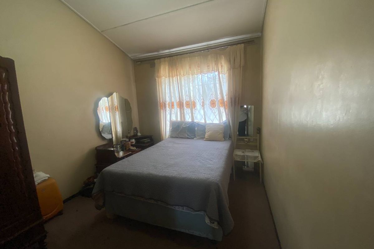 A bedroom featuring neutral walls and carpeted flooring, offering a blank canvas for potential updates and modernization.