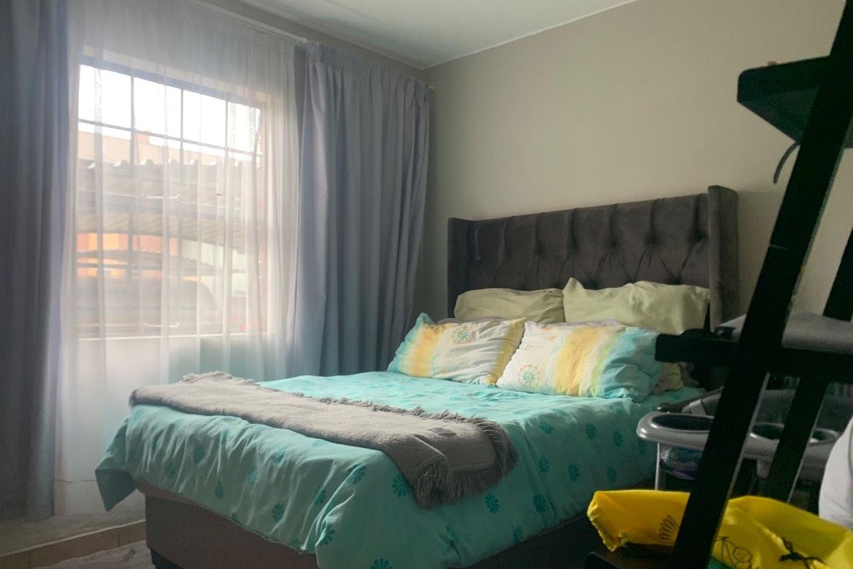 A bedroom featuring a window with curtains and neutral wall finishes.
