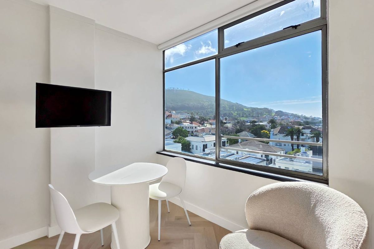 Bright living area featuring herringbone timber flooring and a large picture window offering expansive neighbourhood and mountain views.