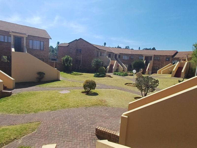 A view of the communal garden area and paved walkways between the brick apartment blocks.