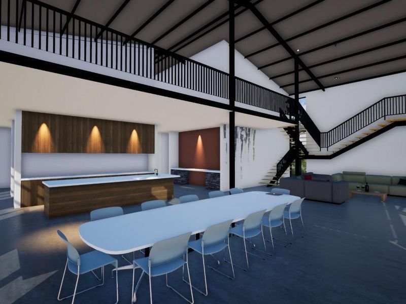 A spacious open-plan living area featuring a modern kitchen island, mezzanine level, and architectural staircase in a contemporary industrial design.