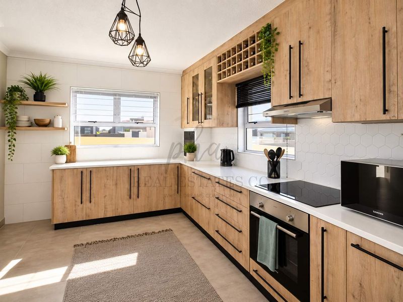 Modern kitchen featuring light wood-grain cabinetry, stone countertops, integrated appliances, and a stylish hexagonal tiled backsplash.