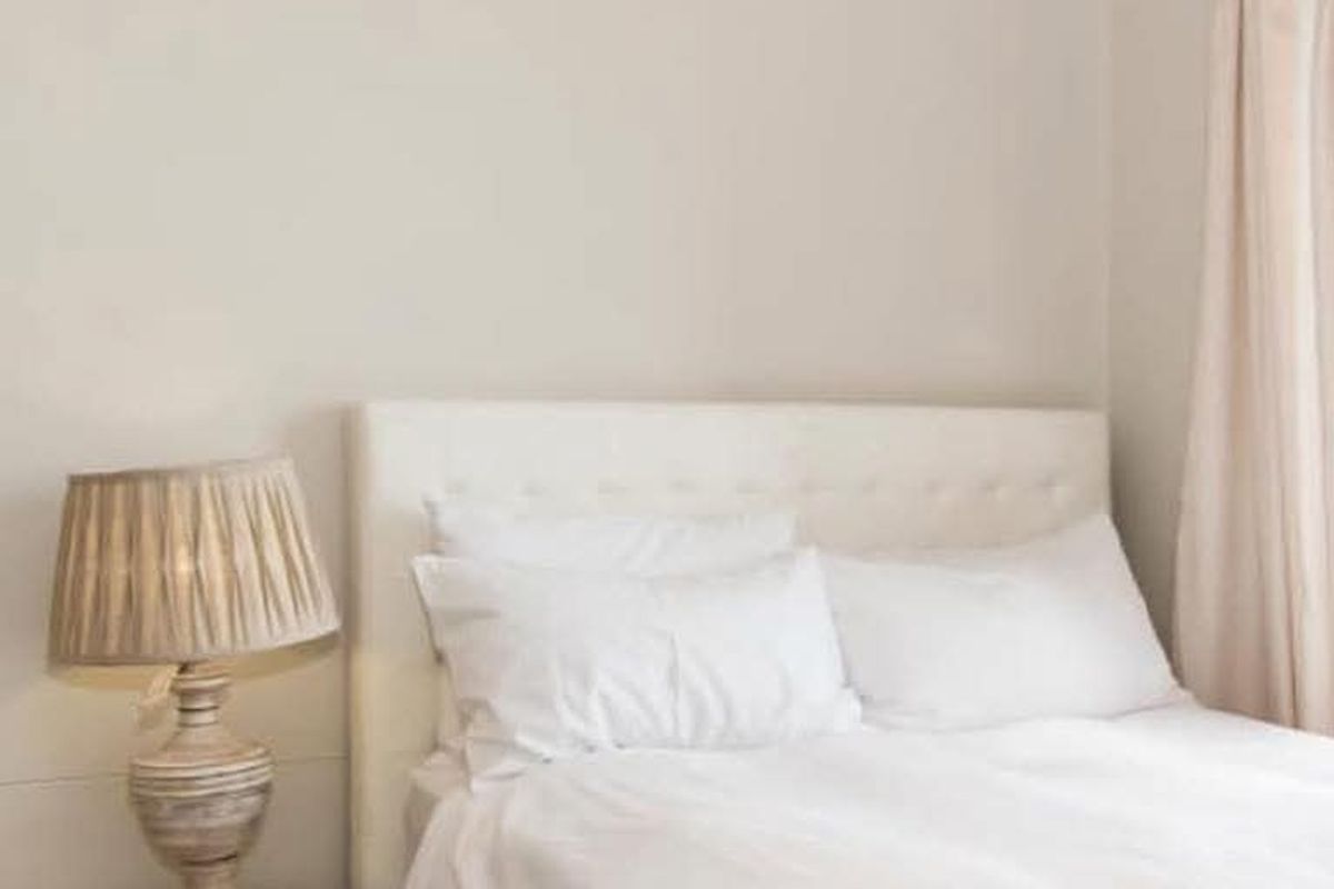 A neutral-toned bedroom featuring crown molding and soft natural lighting, creating a calm and inviting atmosphere.