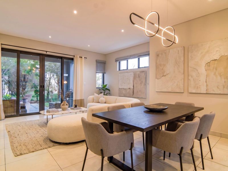 A bright and modern open-plan living and dining area featuring tiled floors, recessed lighting, and large sliding glass doors leading to the patio.