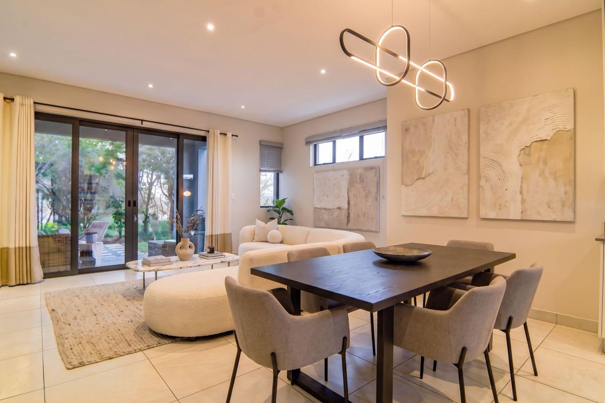 A bright and modern open-plan living and dining area featuring tiled floors, recessed lighting, and large sliding glass doors leading to the patio.