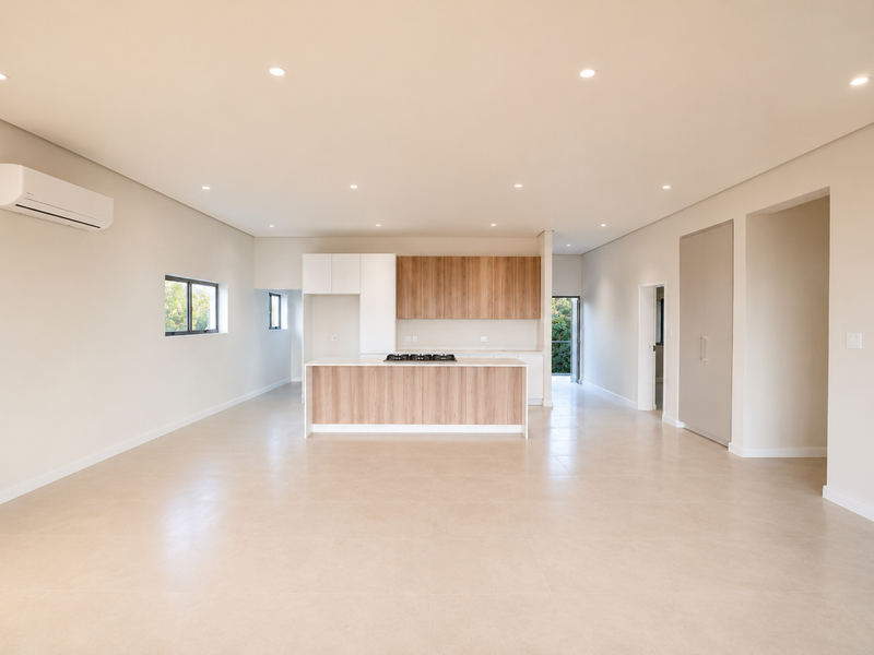 Spacious open-plan living and kitchen area featuring modern wood-finish cabinetry, a central island with a gas hob, tiled floors, and integrated air conditioning.