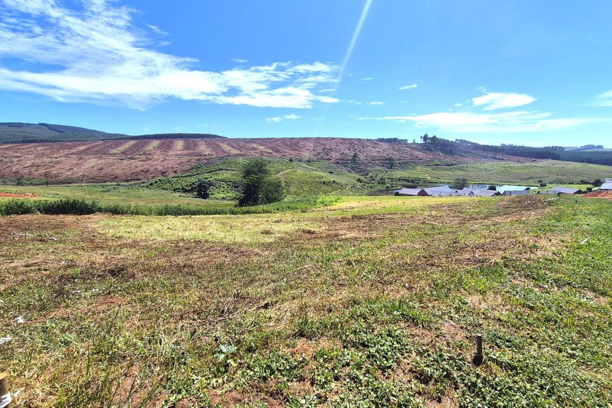 A wide-angle view of a vacant residential plot featuring rolling hills and natural landscape scenery.