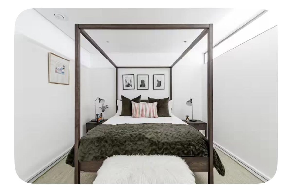 A well-maintained bedroom featuring clean white walls, recessed ceiling lighting, and high-level clerestory windows providing natural light.