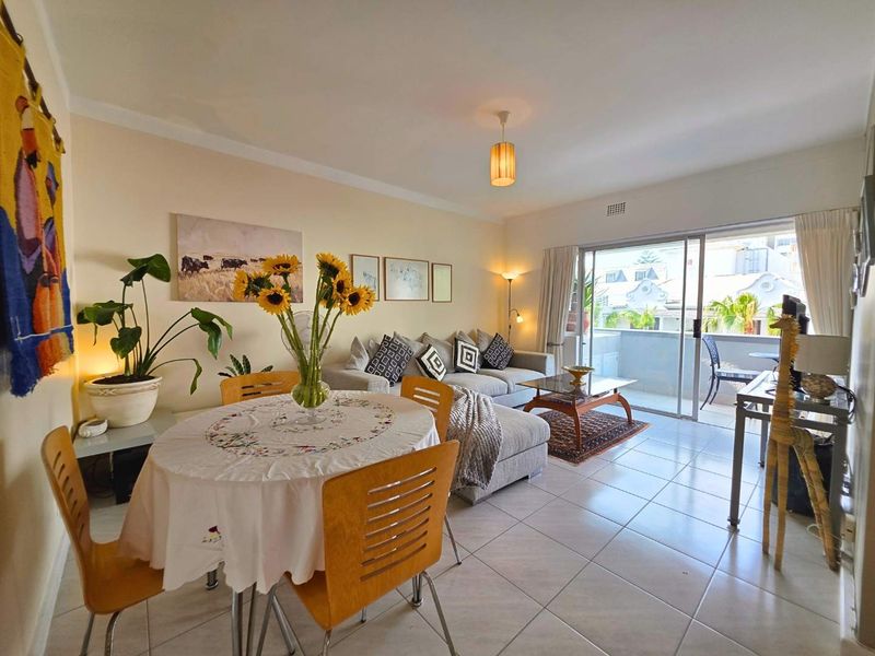 Open plan living and dining area featuring tiled flooring and large sliding glass doors leading to an outdoor balcony.