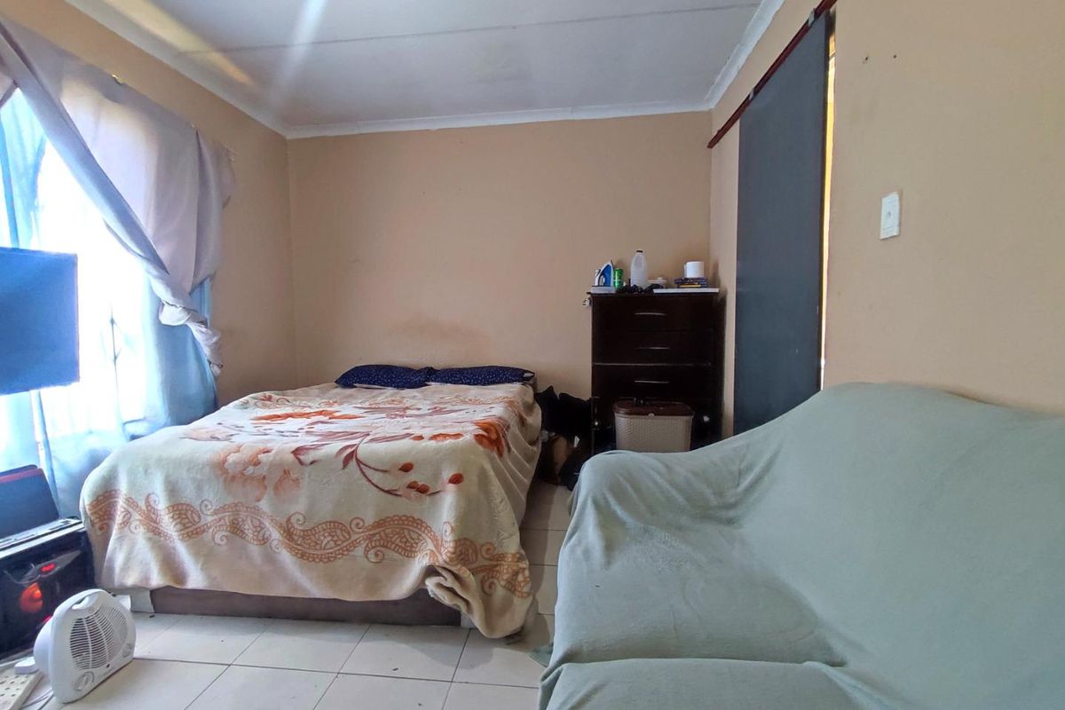 A bedroom featuring tiled flooring and neutral wall tones, providing a functional space for rest.