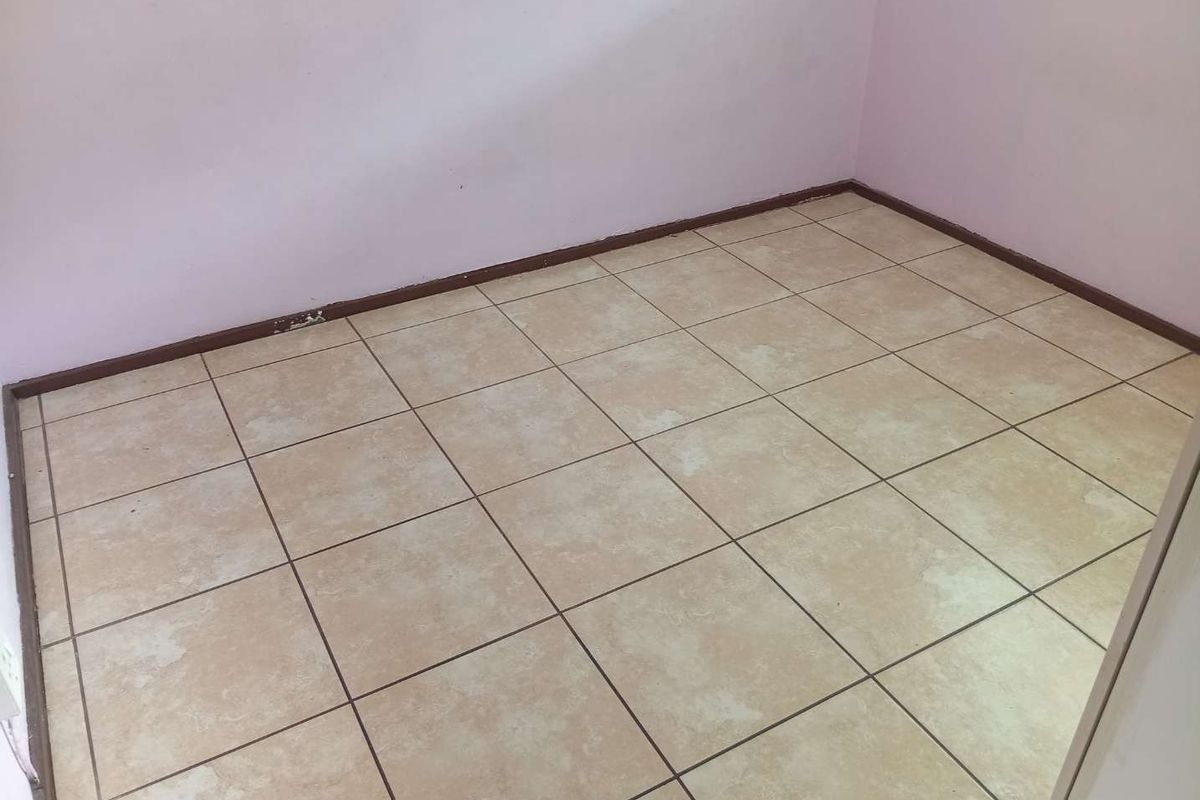 An empty bedroom featuring neutral ceramic floor tiles and painted walls, providing a blank canvas for potential interior design updates.