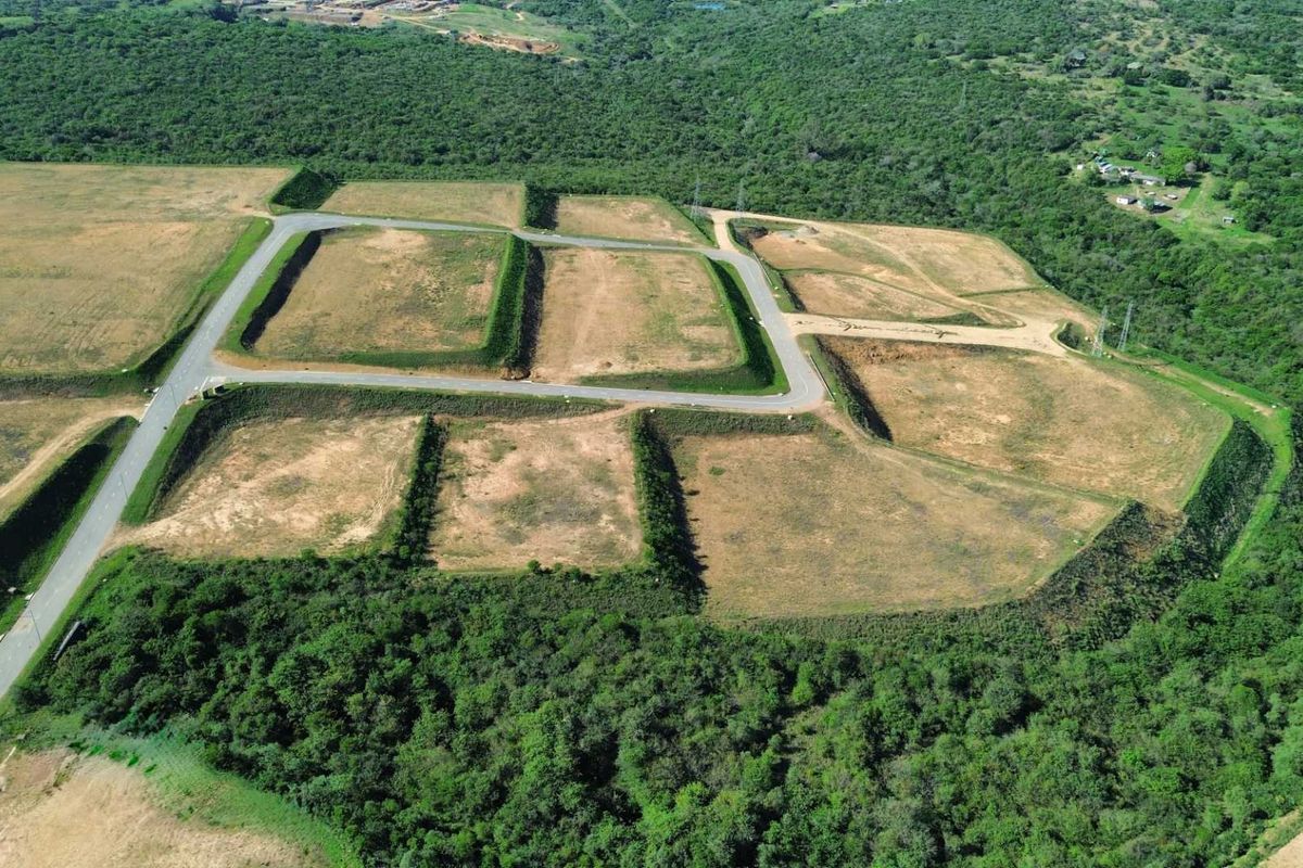Aerial view of a developed industrial land site featuring multiple terraced plots with established paved access roads and surrounding natural vegetation.