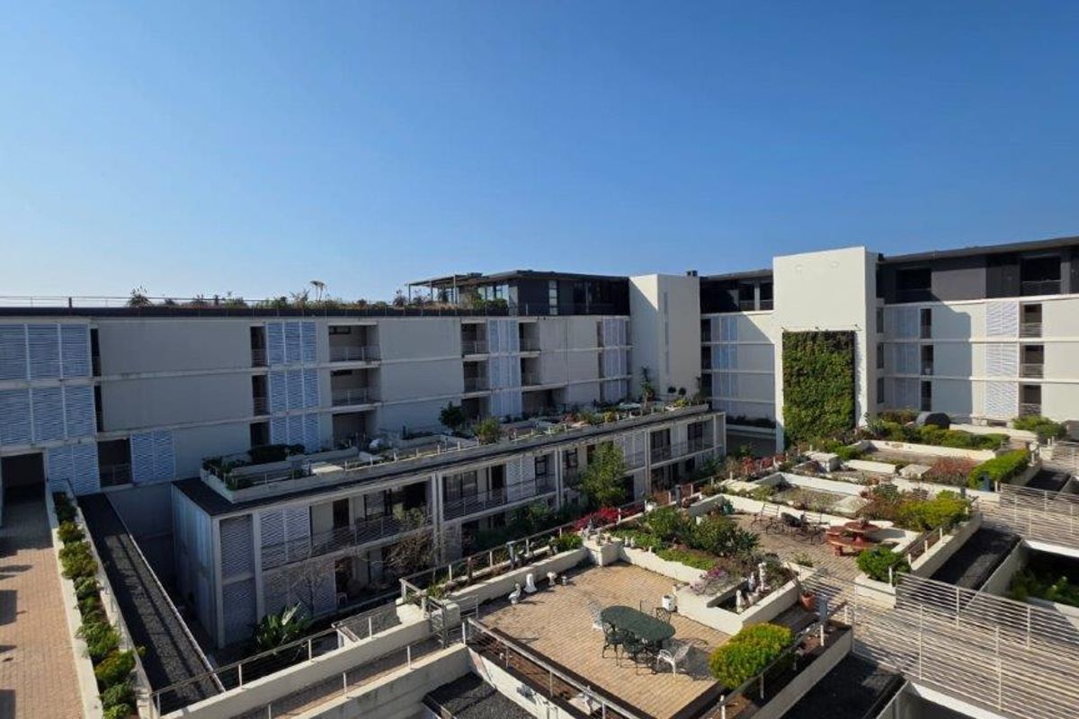 Elevated view of the apartment complex featuring tiered terraces, vertical garden installations, and modern architectural design with integrated outdoor living spaces.