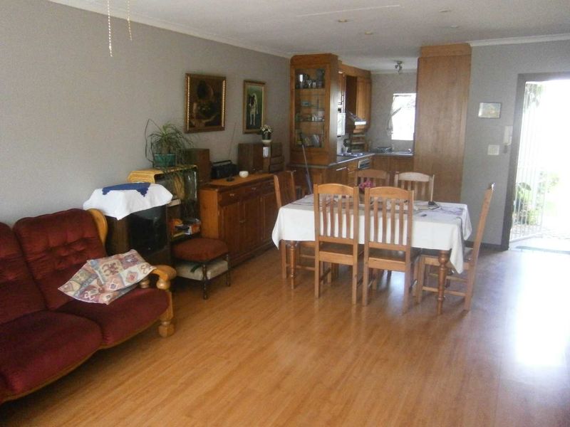 Open plan living and dining area featuring laminate flooring and integrated kitchen cabinetry, offering a functional layout for daily living.